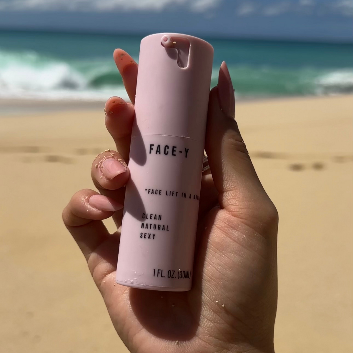 Facelift In A Bottle held in hand at the beach