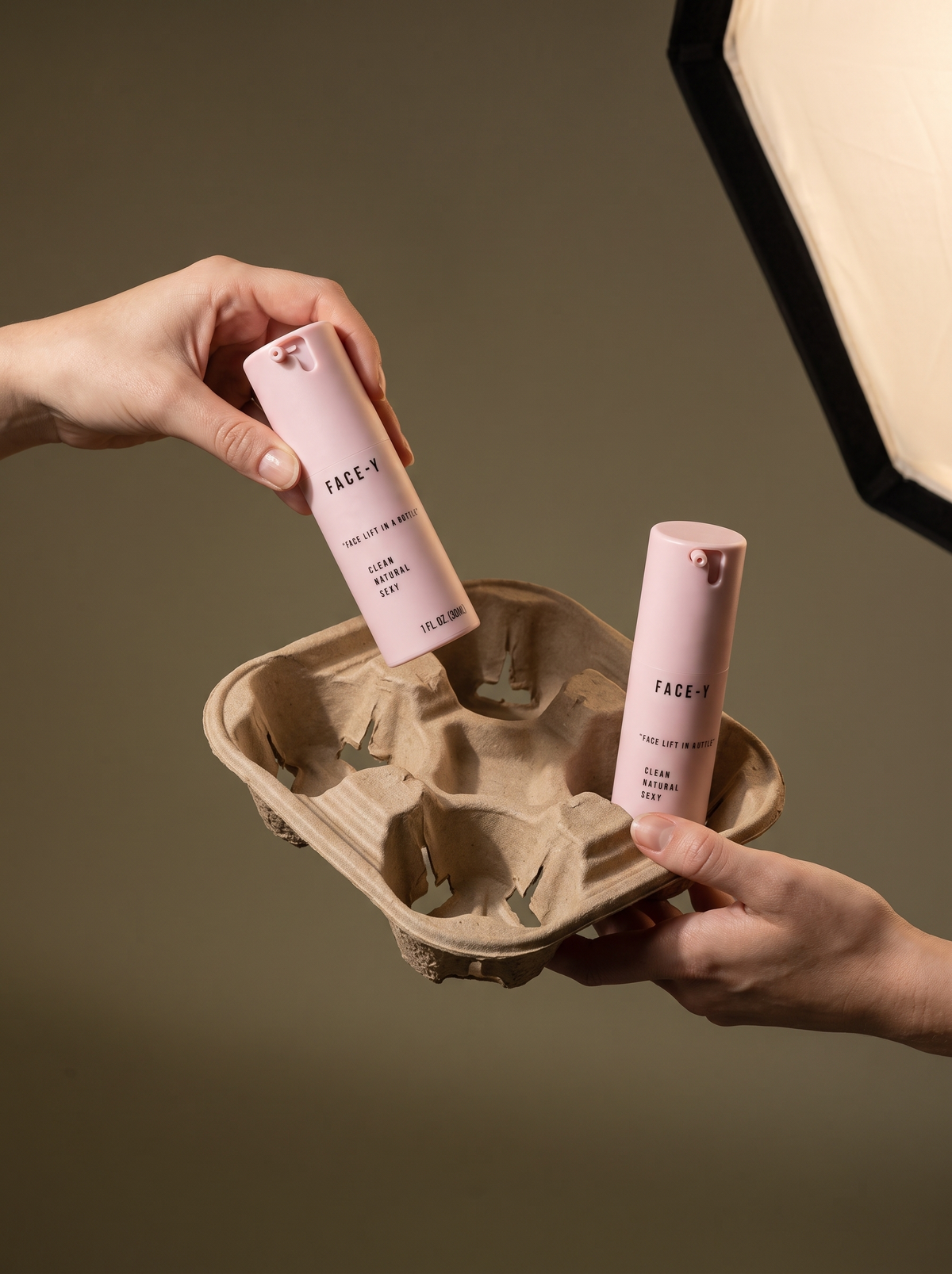 Hands holding Face-y serum bottles