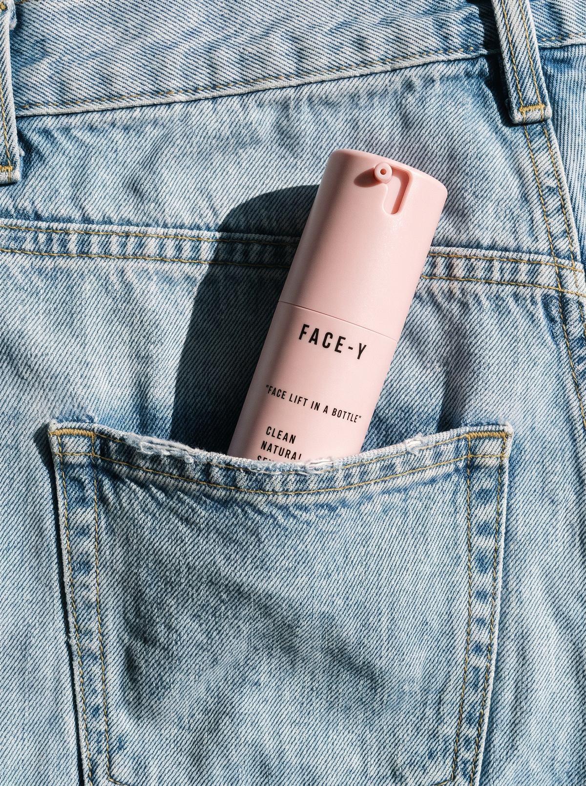 Face-y bottle in a jeans back pocket
