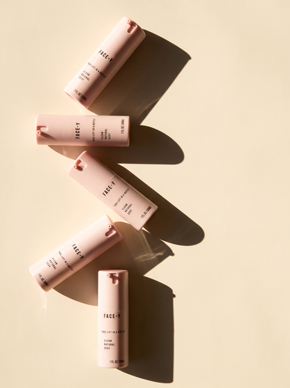 Five Face-y serum bottles stacked on cream with soft shadows